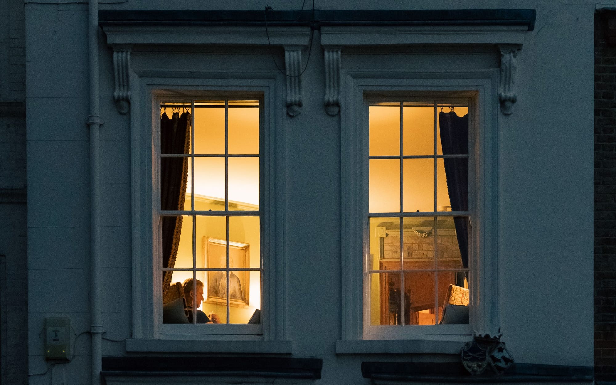 A Mayfair townhouse frontage with warm interior light at dusk